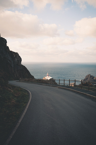 Red and white lighthouse in the coast of spain during a clear day with copy space , relax and inspiration concept