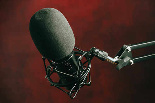 A close up of a streaming microphone over a red background with copy space