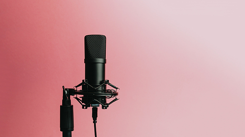 Minimalistic image of a streaming microphone over an pastel pink background with copy space, minimal concept, technology streaming