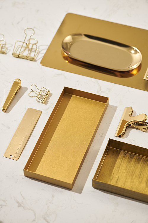 Gold items. Flat lay. Accessories on the table, woman desk top. View top table, background mock up. Envelope top