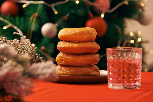 Christmas interior of kitchen with wooden table and donuts and blurred xmas tree decoration