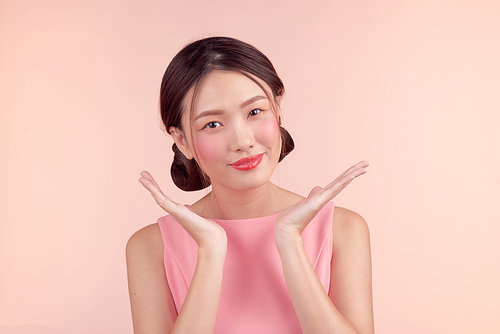 Fashion portrait of a beautiful young woman in a pretty dress over pink background