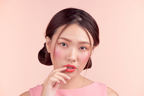 Beautiful asian girl with professional makeup and stylish hairstyle  isolated on pink. Cosmetics and make-up