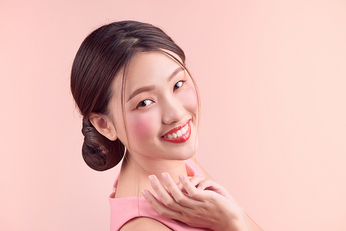 Beautiful asian girl with professional makeup and stylish hairstyle  isolated on pink. Cosmetics and make-up