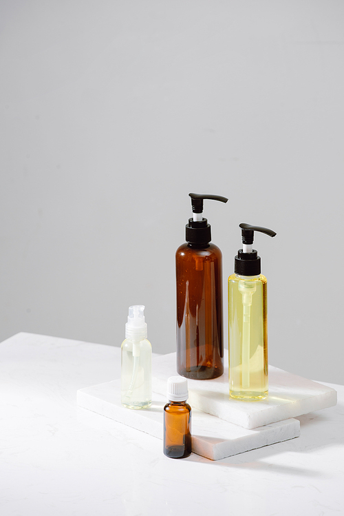 Spa cosmetics in brown glass bottles on gray concrete table. Copy space for text. Beauty blogger, salon therapy, branding mockup, minimalism concept