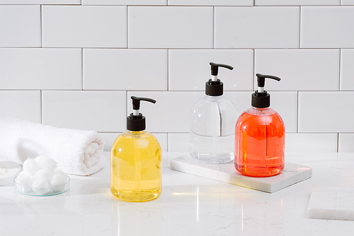 Cosmetic bottles with shower gel, body lotion or shampoo and bath towels. Bathroom accessories.