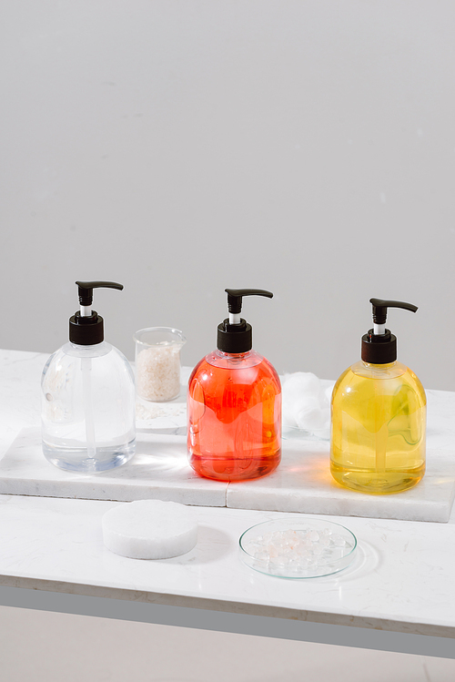 Cosmetic bottles with shower gel, body lotion or shampoo and bath towels. Bathroom accessories.