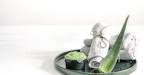 Spa still life with organic skincare, fresh aloe leaf and towels. The concept of beauty and organic cosmetics.