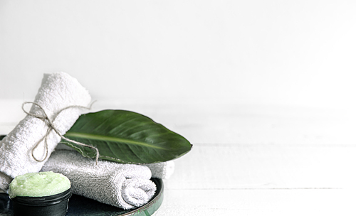 Spa still life with organic skincare, natural leaf and towels. The concept of beauty and organic cosmetics.