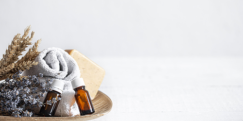 Still life with towels, soap and aromatic oils in jars. Aromatherapy and health care concept.