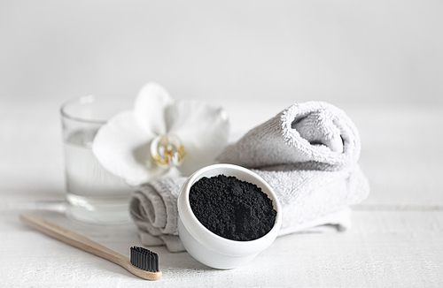 Still life with an organic wooden toothbrush with a glass of water and natural teeth whitening powder. Oral hygiene and dental care.