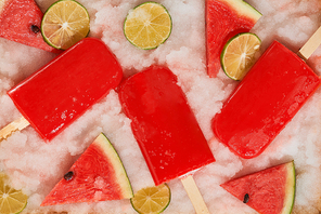 Watermelon popsicles and sliced lemon on ice filled tray