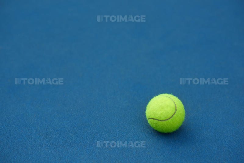 유토이미지 | Yellow bright tennis ball is lying on on blue carpet. Made for playing tennis. Contrast image with satureted... 