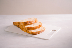 freshly baked bread on wooden cutting board isolated on white