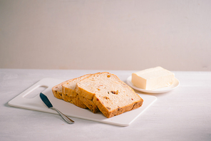 Fresh bread and homemade butter on white table
