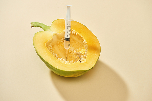 Bright ripe papaya fruit with syringe extracting liquid and showing concept of cellulite treatment