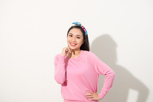 Asian woman with fist on her chin, making smart act, bright feeling, pink shirt, white background