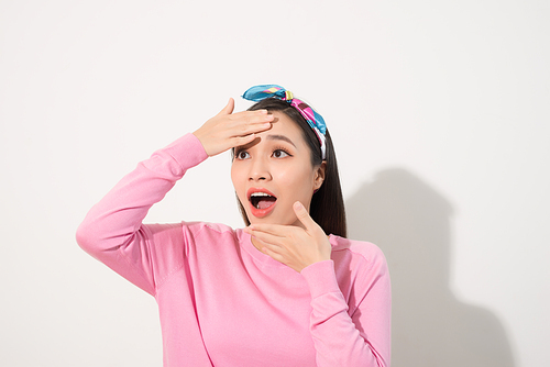 Asian woman touching her face with surprise feeling, with joy and happiness, pink shirt, white background
