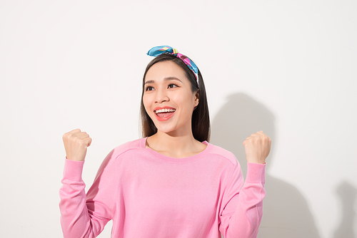 Surprised woman with hands up amazed or shocked by unexpected news holding close palms up and showing happy expression. Young adult woman on white background
