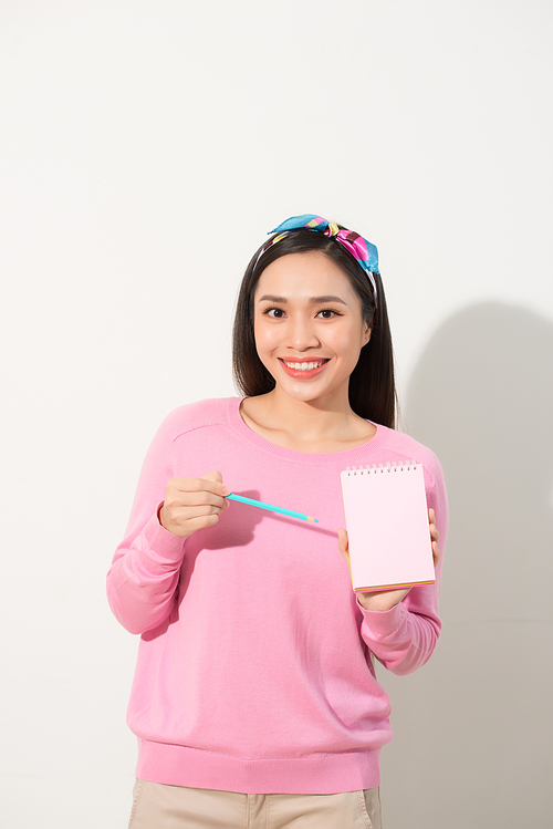Closeup image of a beautiful Asian woman holding and showing blank notebook