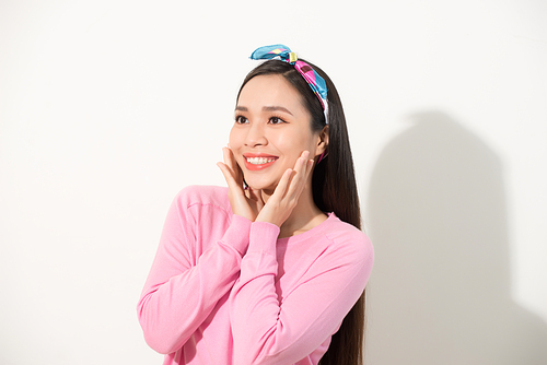 Cute asian presenting her face with hands touching face in v shape, portrait, skincare and cosmetic concept, pink shirt, white background