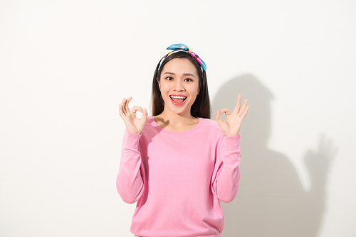 Young pretty asian woman showing OK sign with two hands. Close up portrait. Isolated on the white background.