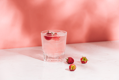 Summer juice with fresh raspberries in a glass on a light background