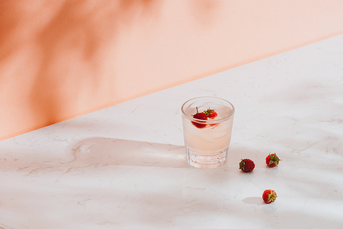 Summer juice with fresh raspberries in a glass on a light background