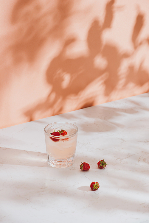 Summer juice with fresh raspberries in a glass on a light background