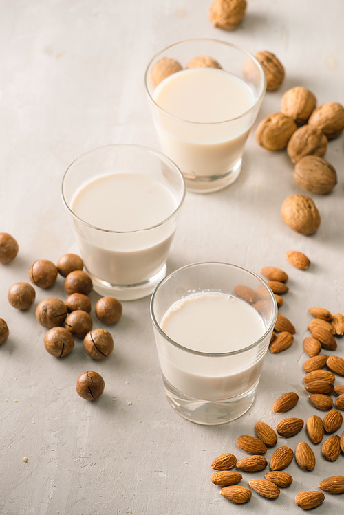 Glasses of milk: Macadamia, almond, walnut. Top view.