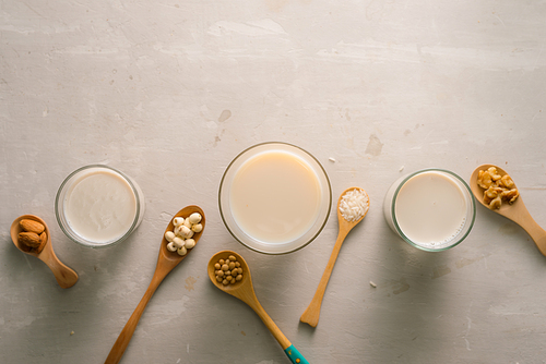 glasses of milk with nuts: macadamia, almond, soy, ., lotus. top view.