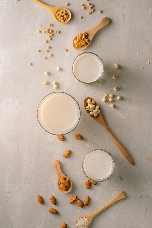 glasses of milk with nuts: macadamia, almond, soy, ., lotus. top view.