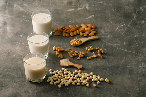 Glasses of milk: Almond, soy, walnut on table.
