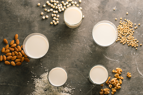 Glasses of milk with nuts: Macadamia, almond, soy, rice, lotus. Top view.