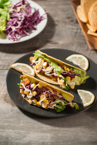 Traditional mexican taco with chicken and vegetables on wooden table. Latin american food.