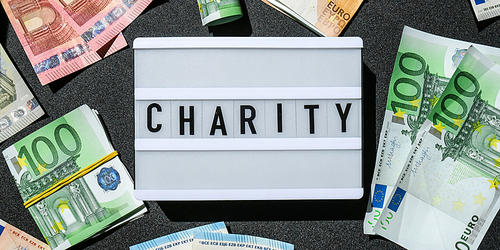 Lightbox board with word CHARITY in black letters around Euro banknotes. Money, Business, finance, investment, saving. Cash bill. Business budget of wealth and prosperity finance