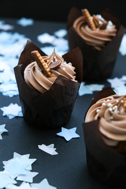 Delicious chocolate cupcakes with cream on dark background. Three chocolate muffin. Birthday cake party. Boy or girl baby party cake Homemade Chocolate Cupcake