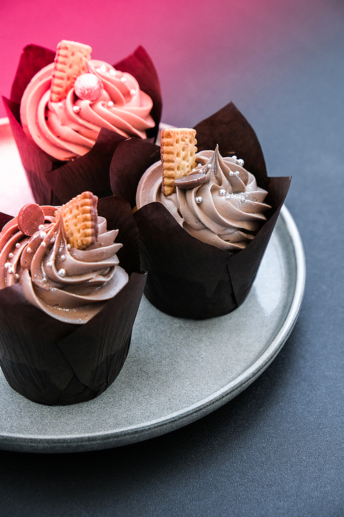 Delicious chocolate cupcakes with cream on dark background. Three chocolate muffin. Birthday cake party. Homemade Chocolate Cupcake