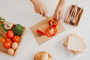 Male hands slicing fresh red bell peppers
