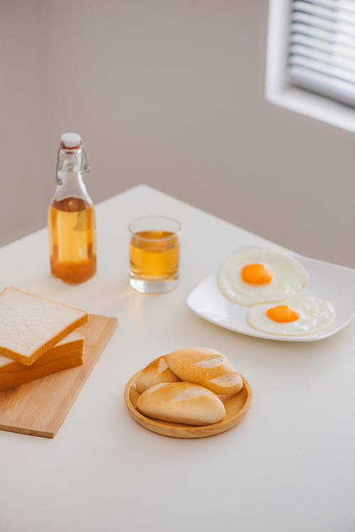 Morning breakfast with glass of tea, toast, fried eggs and bread on table