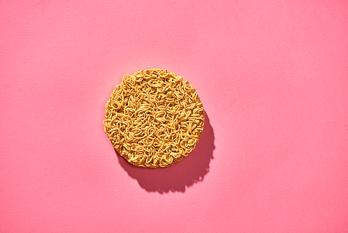 Dried instant noodles isolated on a pink background