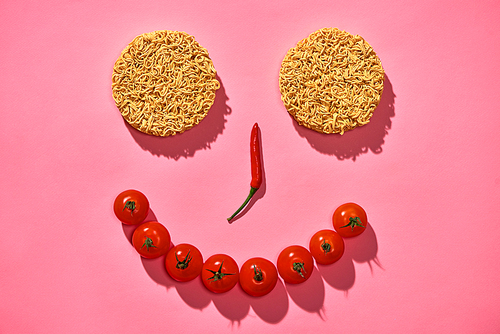 Food concept. face made of hot chilli, tomatos, noodle on pink background