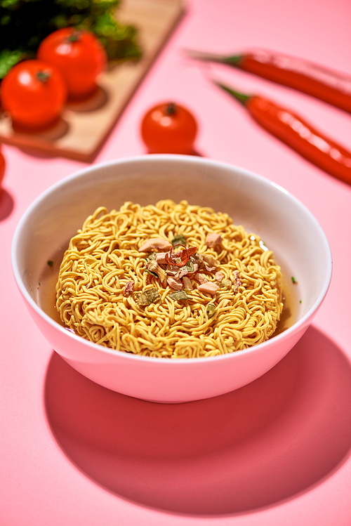 A Bowl of instant noodles on pink background