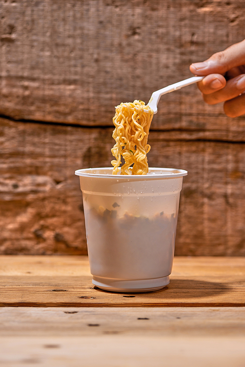 instant noodle, asian fast food, noodle cup on wooden background.