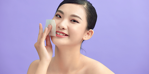 beauty skin care woman smile and using facial oil blotting paper