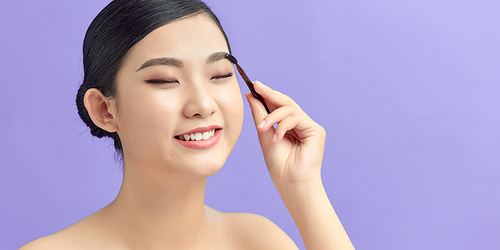 beautiful young woman comb her eyebrows with brush