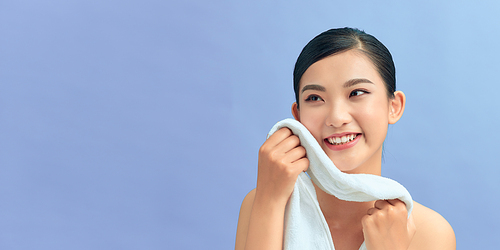 happy woman cleaning her face by using a towel