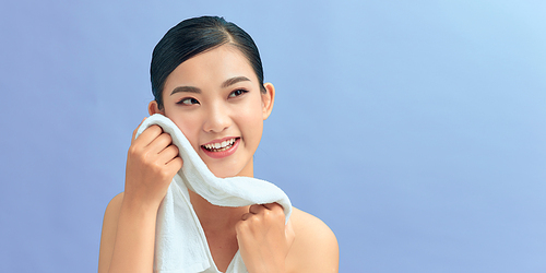 Young beautiful woman using a cotton towel to remove her makeup.