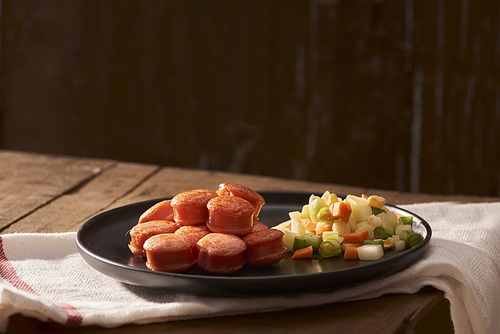 Sliced and fried sausage with salad seen from above close