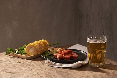 Beer and appetizing beer snacks set. Table with mug beer grilled sausages with sauces.